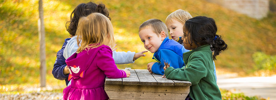 Photo of children playing at a picnic table
