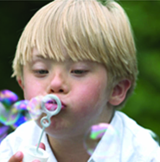 Blonde boy blowing bubbles