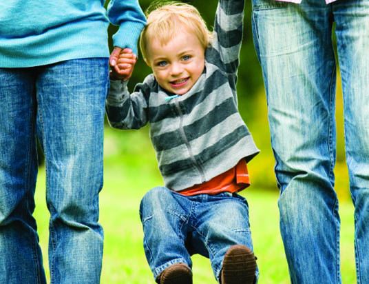 Young boy jumping in the air with mom and dad page 15