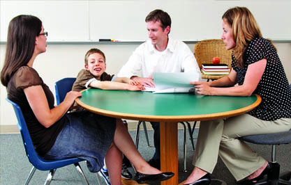 Educational professional, child, male and female caregiver sitting at a table talking to each other in a classroom Page 38