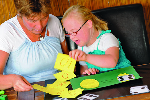 Women working on a paper craft project with a child