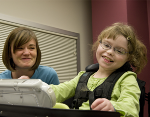 Young girl with aac device and therapist